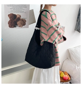 Vue latérale du grand sac cabas noir matelassé avec surpiqûres sur un mannequin
