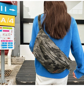 Close-up of camouflage canvas shoulder bag with durable metal zipper and strap details
