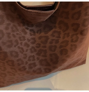 Gros plan sur le sac cabas imprimé léopard montrant la texture du daim et les coutures