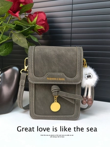 Detail view of retro green leather texture with gold lettering and cute plush pendant