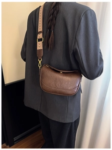 Détail du sac bandoulière en cuir marron foncé avec sangle ethnique et boucle métal