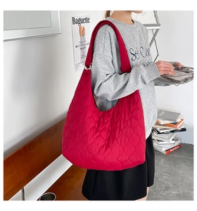 Détail macro de la texture matelassée rouge et bandoulière large du sac en nylon