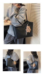 Detail of black leather tote bag with a cute brown plush bear charm and gold lettering