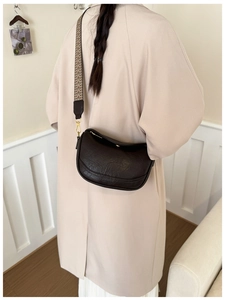 Sac bandoulière demi-lune marron foncé avec sangle tissée géométrique, style minimal