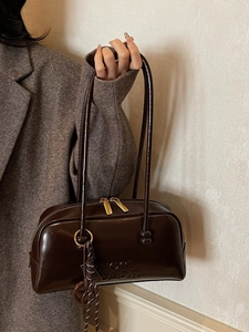 Retro dark brown glossy leather pillow bag with top handles and gold hardware details