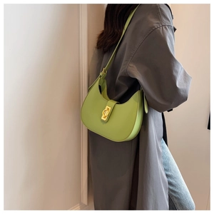 Detail of green crescent underarm bag with gold ring clasp and slim shoulder strap