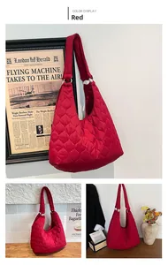 Détail du sac hobo matelassé rouge avec finition brillante et anneaux en métal argenté