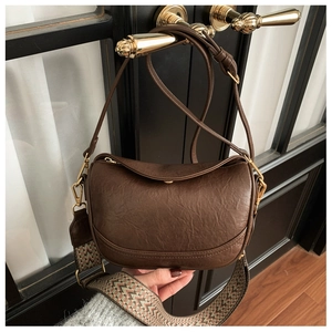 Détail du sac demi-lune marron foncé avec cuir texturé rétro et détails dorés