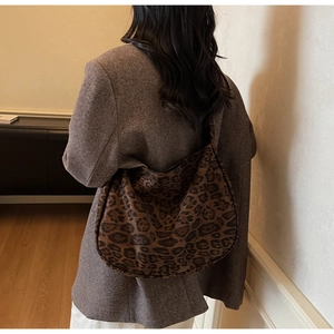 Back view of model wearing a large leopard print shoulder bag in brown fuzzy fabric