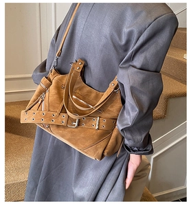 Detail of vintage brown punk tote bag featuring metallic rivets and silver belt buckle trim