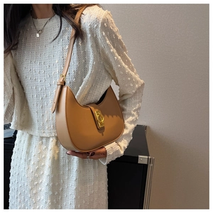 Close-up of brown PU leather crescent shoulder bag with golden hardware and strap
