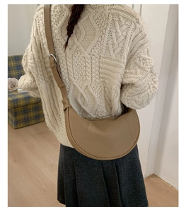Back view of khaki crescent shoulder bag styled with a minimalist knit sweater for autumn