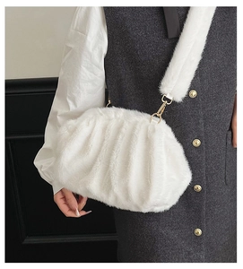 Detailed shot of white faux fur cloud bag with soft pleats and golden metal buckle