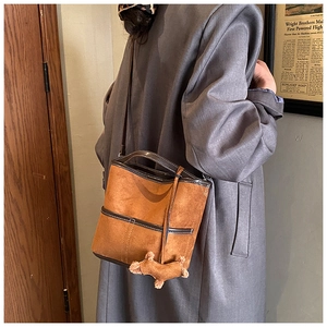 Sac seau vintage en daim marron avec coutures décoratives et un joli porte-clés chien