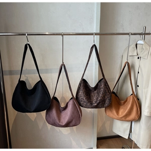 Detail of suede hobo bags in black, rose, leopard and caramel for winter outfits