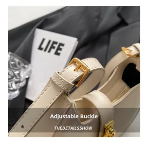 Detail showing the adjustable golden buckle and premium zipper closure of the beige bag