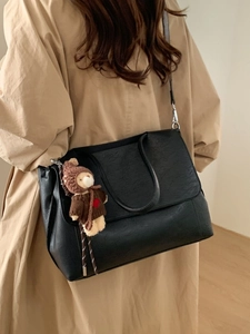 Minimalistische schwarze Achseltasche aus Kunstleder mit Bärenanhänger für Damen