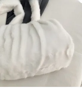 Detail of white plush faux fur tote bag showing vertical pleated texture and soft fabric