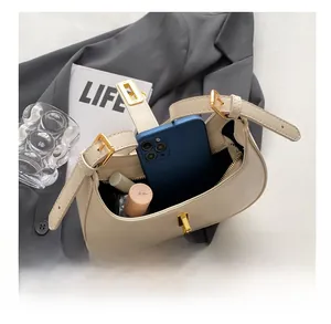 Detailed interior of a beige underarm bag showing capacity for phone and lipstick