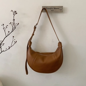 Detail of brown lychee grain leather crossbody bag showing premium stitching and hardware