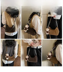 Detail view of vintage-style half-moon bags in brown and khaki with metal chain straps
