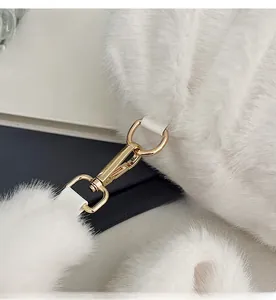 Macro shot of light gold metal hooks and white leather loops on fluffy plush bag