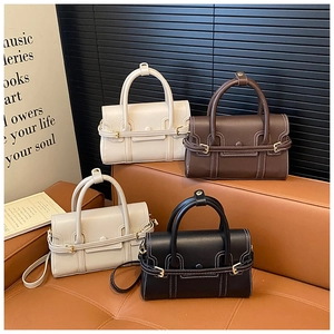 Detailed view of stylish bowling handbags in four colors on a vintage leather sofa
