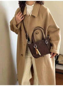 Détail du sac seau plissé marron foncé avec breloque en perles de bois et bandoulière