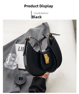 Detail of black PU leather crescent bag featuring a metallic gold twist lock and strap