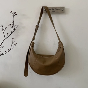 Close-up of brown litchi grain leather hobo bag with sleek silver metal buckle detail