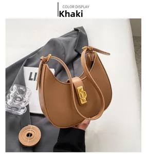 Detail view of khaki half-moon shoulder bag with golden metal buckle and leather strap