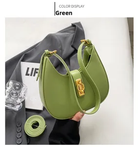 Detail view of green crescent shoulder bag with golden round buckle and smooth PU leather