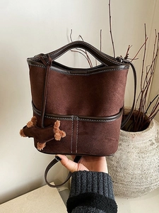 Sac seau rétro en daim marron foncé avec surpiqûres blanches et pendentif peluche