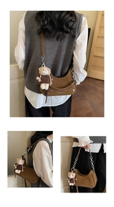 Detail view of brown hobo bag with silver chain strap and cute bear plush charm accessory