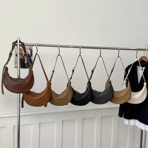 Chic dumpling-shaped half-moon shoulder bags in seven versatile colors on a rack
