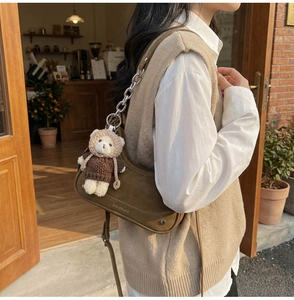 Brown suede crescent bag with metal chain strap and cute teddy bear charm detail