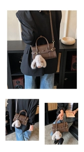 Detail of brown leather bowling bag with contrast stitching and plush bunny charm
