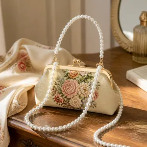 Detail van de parel schouderriem op vintage bloementas met roos borduurpatronen