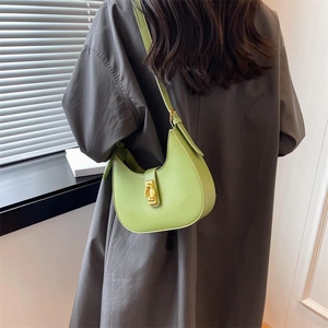 Back view of minimalist light green hobo bag with gold clasp on a model in grey dress