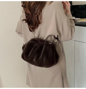 Detail of plush dark brown dumpling bag with soft faux fur texture and metal buckle