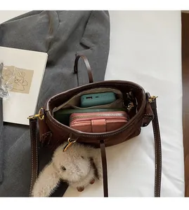 Interior view of large capacity dark brown suede shoulder bag holding gadgets