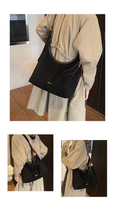 Détail du sac cabas en daim avec perles en bois marron et pompon sur un sac hobo