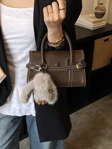 Brown leather bowling handbag with white stitching and cute rabbit charm detail