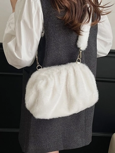 Elegant white faux fur cloud bag with pleats and gold metal rings shown on a model