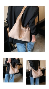 Détail d'un sac cabas en daim vintage avec pompon à franges et breloque fleur dorée
