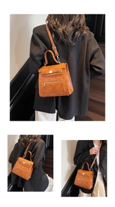 Close-up of vintage brown leather handbag featuring pebble texture and silver hardware details