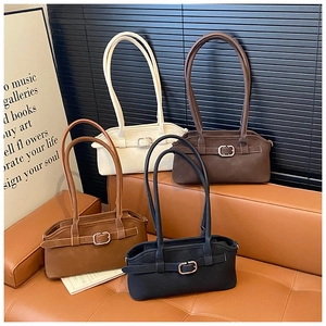 Détail de quatre sacs à bandoulière en cuir mat en crème marron et noir sur canapé