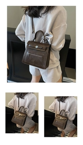 Detailed view of dark brown vintage faux leather backpack with metallic buckle and handle