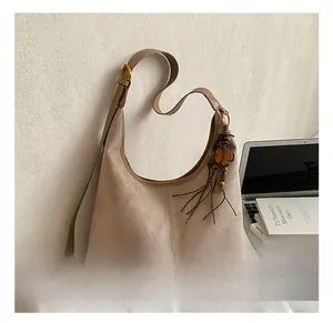 Détail du sac hobo avec pompon fleur vintage et texture en daim de haute qualité
