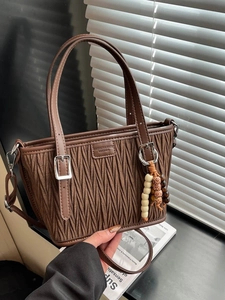 Sac seau plissé marron avec bandoulière et pendentif perlé au style minimaliste